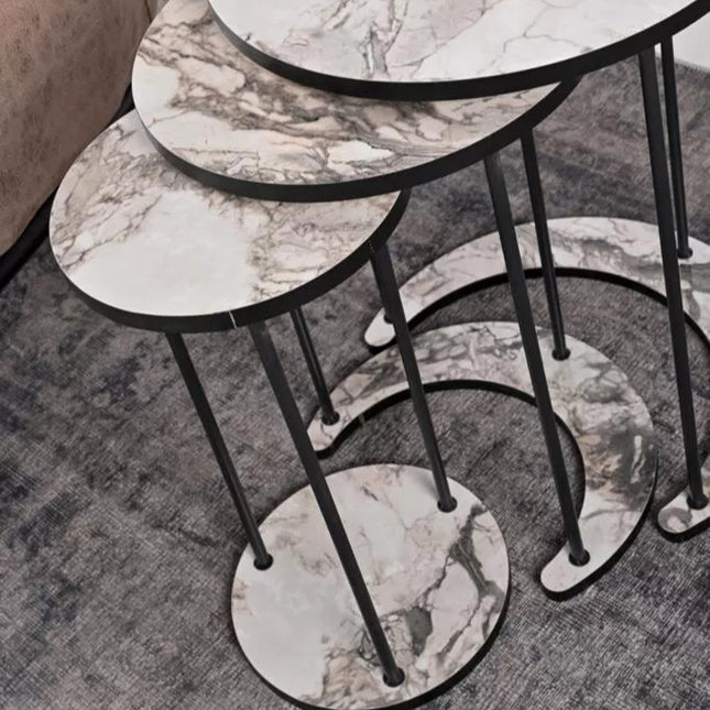Set of marble-patterned side tables on a carpeted floor.