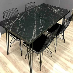 Dining table set with black marble top and matching chairs on a wooden floor.